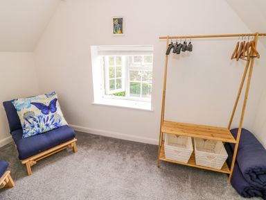 A room with two chairs and a hanger with baskets at The Cottage in Ettington