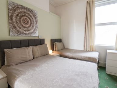 A bedroom with a double bed and a single bed next to a window at Beach in Bridlington