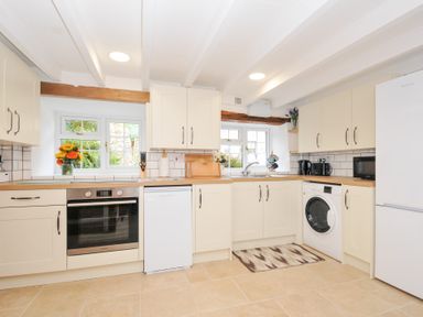 A kitchen with white cabinets and appliances at Henwood Barn Henwood near Upton Cross