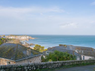 A coastal view with houses and sea in the background at Godrevy Shepherds Hut Angarrack near Hayle