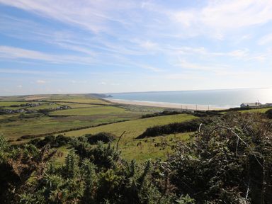 A coastal landscape with fields houses and a beach by the sea at Ty Rhosyn in Penycwm near Solva