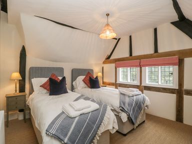 A bedroom with two single beds and bedside tables with lamps at Byways in Madresfield near Malvern