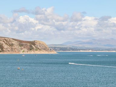 A coastal scene with boats on the water and hills in the background at 7 Maes Awel in Abersoch