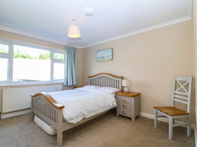 A bedroom with a bed and nightstand at 7 Maes Awel in Abersoch