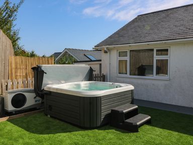 A hot tub with steps and an air conditioning unit at 7 Maes Awel in Abersoch