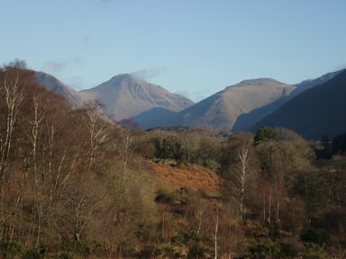 A landscape with trees and mountain hills under a clear sky at Church How Cottage Nether Wasdale