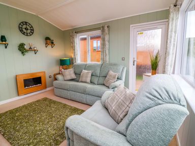 A living room with a sofa and armchair at Daffodil Lodge Mullacott near Ilfracombe