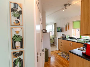 A kitchen with a refrigerator and cabinets at Daffodil Lodge Mullacott near Ilfracombe