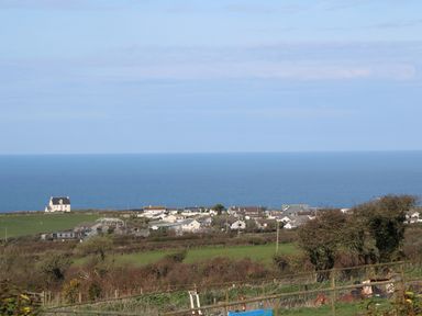 A coastal village with houses and fields overlooking the sea at Chilowan Trewarmett near Tintagel