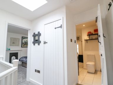 A hallway with doors leading to a bedroom and a bathroom at Ellie's Cottage in Burford