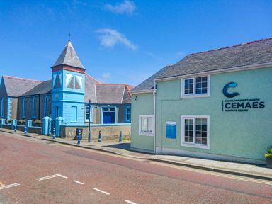 A street view with buildings including the Cemaes Heritage Centre at Bwthyn Lili in Cemaes Bay