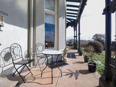An outdoor patio with metal chairs and tables and potted plants at Ismay Dining Room Suite - Titanic Interest in Waterloo Merseyside
