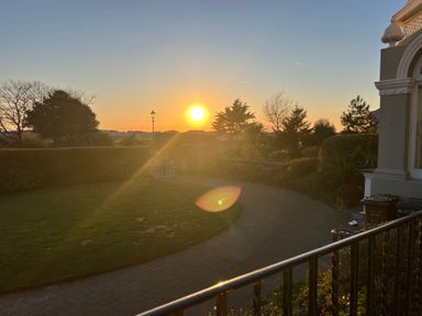 A garden with trees and a pathway at sunset at Ismay Dining Room Suite Titanic Interest in Waterloo Merseyside