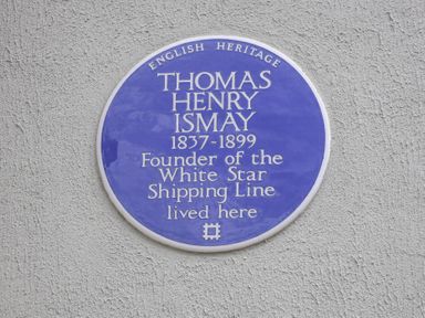 A blue English Heritage plaque on a textured light gray wall commemorating Thomas Henry Ismay founder of the White Star Shipping Line at Ismay Dining Room Suite Waterloo Merseyside