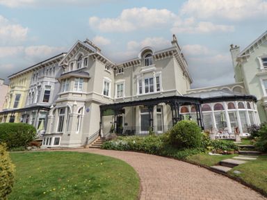 A large traditional building with a covered porch and garden path at Ismay Dining Room Suite - Titanic Interest in Waterloo Merseyside
