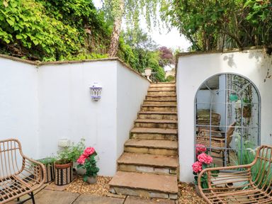 A garden with stairs and outdoor seating at Lower Pack Horse Cottage in Winchcombe