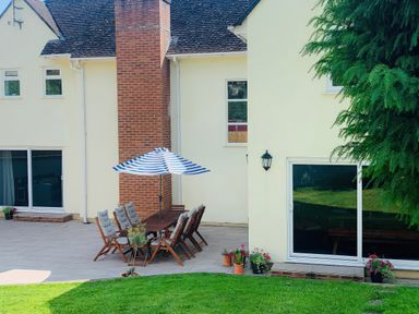 An outdoor patio area with a table and chairs at Brooklands in Uplyme