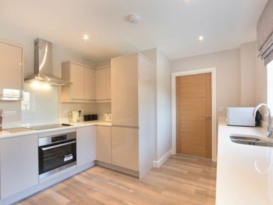 A kitchen with cabinets oven stove microwave and sink at Sans Souci in Seahouses