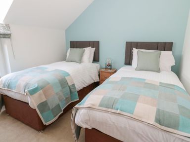 A bedroom with two single beds and a nightstand at Rose Lodge in High Newton-by-the-Sea near Embleton