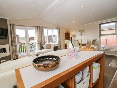 An open living and dining area with a wooden shelf holding a decorative bowl and tissue box at Walkers Rest in Warton near Carnforth