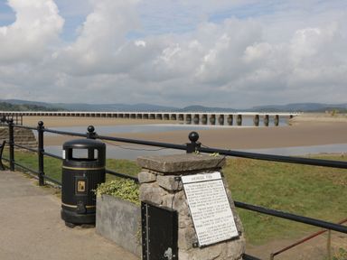 A view of Arnside Pier and surrounding landscape with railing and information plaque at Walkers Rest in Warton near Carnforth