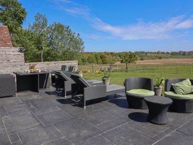 An outdoor seating area with a dining table and sun loungers at Polly's Annexe in Levington