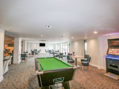 A leisure room with a pool table tables with chairs and a gaming machine at The Olive Lodge 227 Sycamore in New Milton