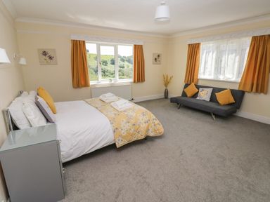 A bedroom with a bed side table and a sofa with cushions at Hillside Lodge in Newtown