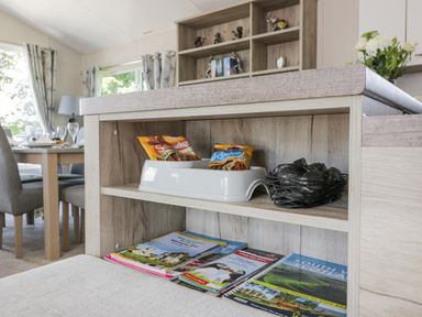 A kitchen island with dog treats and waste bags on a shelf and magazines on a lower shelf at Olivias Haven in Wemyss Bay