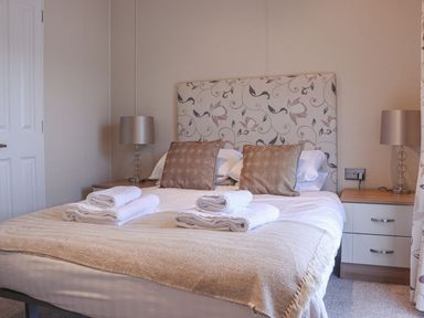 A bedroom with a double bed two bedside tables and two lamps at Tiptoes Lodge in Carnforth