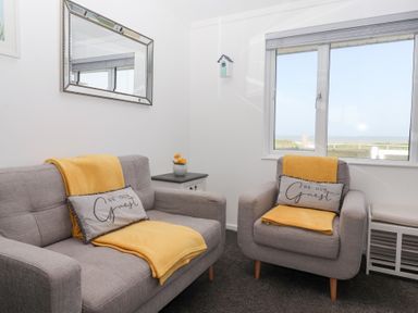 A living room with a sofa and armchair at Bonny Bay in Wilsthorpe near Bridlington