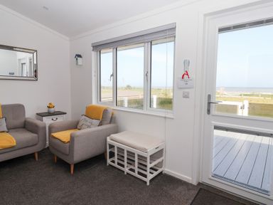 A living room with sofas and a window at Bonny Bay in Wilsthorpe near Bridlington