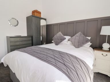 A bedroom with a bed and wardrobe at Bonny Bay in Wilsthorpe near Bridlington