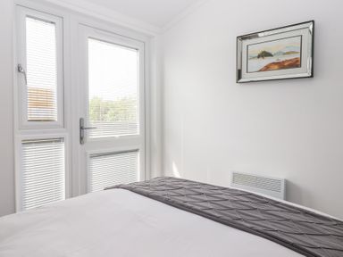 A bedroom with a bed and window at Bonny Bay in Wilsthorpe near Bridlington