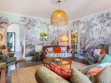 A living room with patterned sofas chairs and a wooden coffee table at Clematis House in St Columb Major