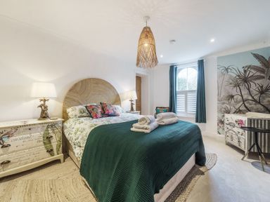 A bedroom with a double bed and bedside tables with lamps at Clematis House in St Columb Major