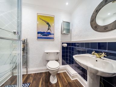 A bathroom with a toilet sink and shower cabinet at Clematis House in St Columb Major