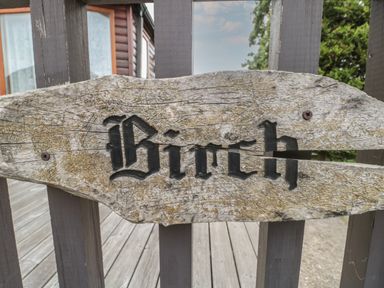 A wooden sign with the word Birch attached to a wooden fence at Birch Swanage
