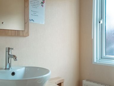A bathroom with a sink and mirror at Willow in Swanage