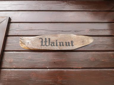 A wooden sign with the word Walnut on a wooden wall at Walnut in Swanage