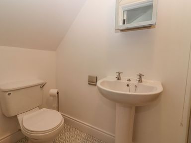 A bathroom with a toilet sink and a mirror above the sink at The Artist's Barn in Ayle near Cappawhite