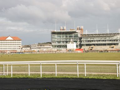 A racecourse with grandstands and large buildings in the background at Bluebell Cottage in Brayton