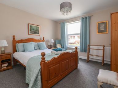 A bedroom with a bed and bedside table at Bluebell Cottage in Brayton