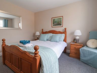 A bedroom with a bed and bedside table at Bluebell Cottage in Brayton