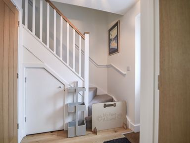 A staircase with carpet and wooden handrails with a no paws allowed sign at Conybeare Cottage in Lyme Regis