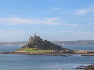 A castle on a small island with surrounding water and distant land in the background at Bodillys Cottage in Newlyn