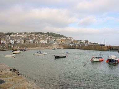 A harbor with boats in the water and houses on the hill at Bodillys Cottage in Newlyn