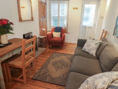 A living room with a sofa and a table at Bodillys Cottage Newlyn