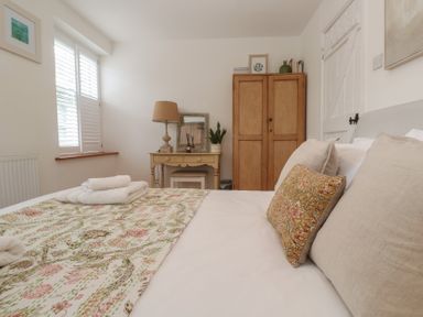 A bedroom with a bed and a wardrobe at Bodillys Cottage Newlyn