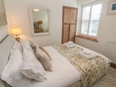 A bedroom with a bed and cupboard at Bodillys Cottage in Newlyn